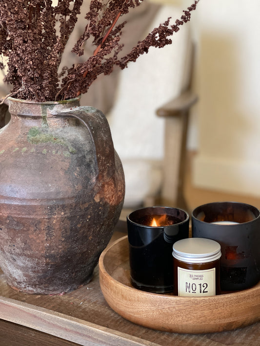 Hand poured French candle in Figuier on coffee table with antique pot and stems