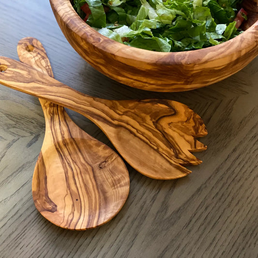 Olive wood salad spoons with salad bowl on table